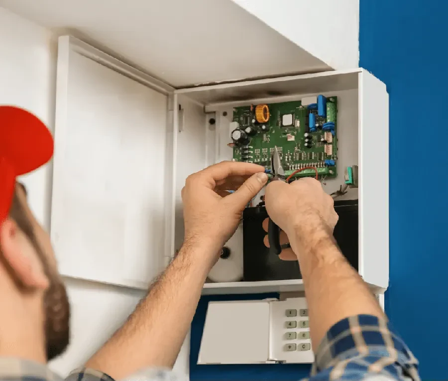 Technician wiring an alarm control panel